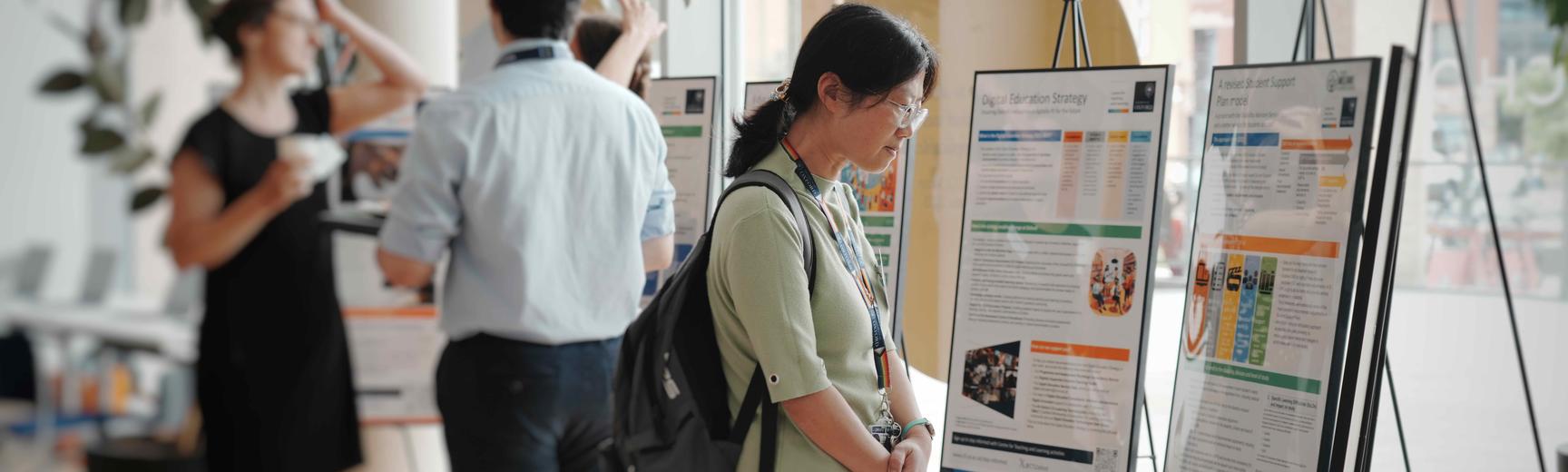 Participant viewing posters at the AI and Teaching and Learning Knowledge Exchange Forum, June 2025