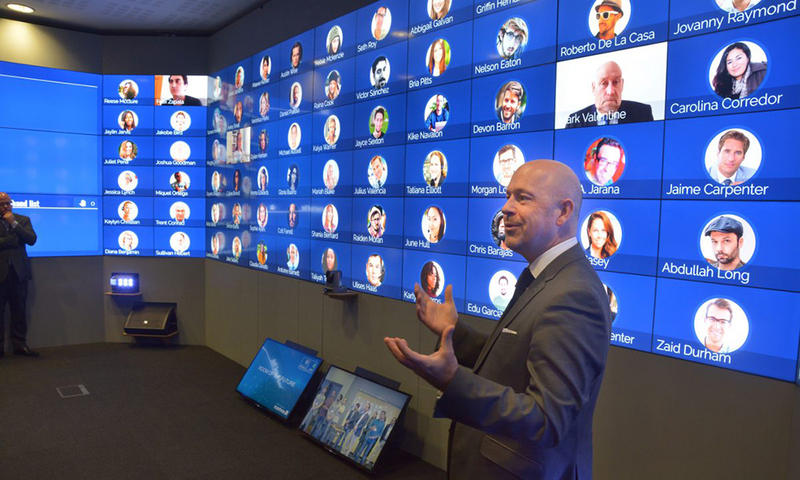 A man standing in a room covered with screens, the Oxford Hub for International Virtual Education (HIVE)